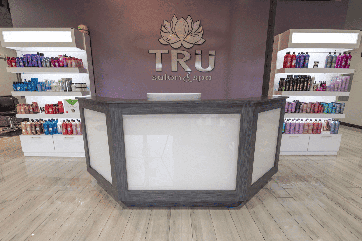 Reception desk at TRÜ Salon & Spa, surrounded by shelves of hair and beauty products.